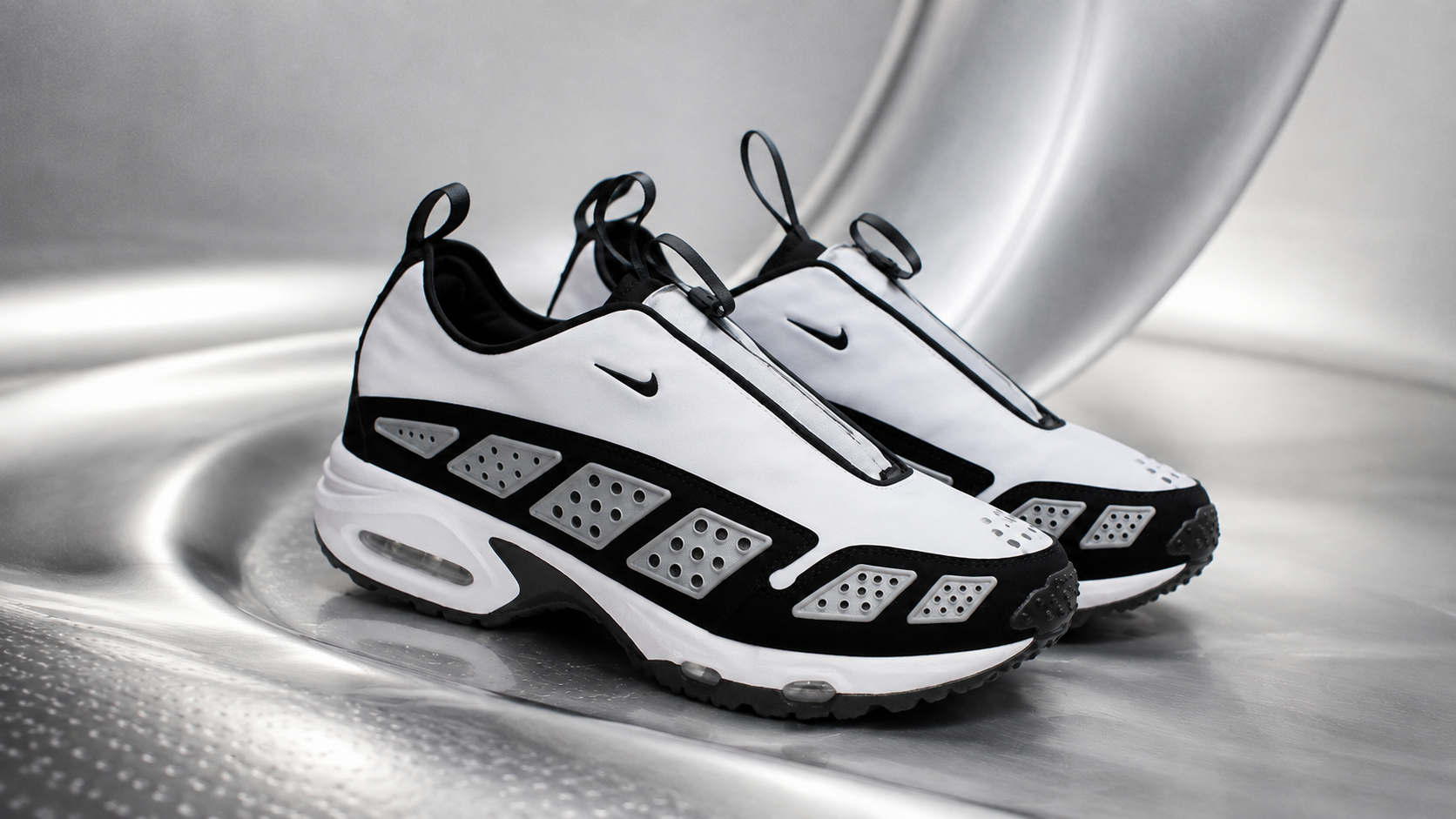 Пара Nike Air Max SNDR в чёрно-белой расцветке в футуристичной студийной сцене
